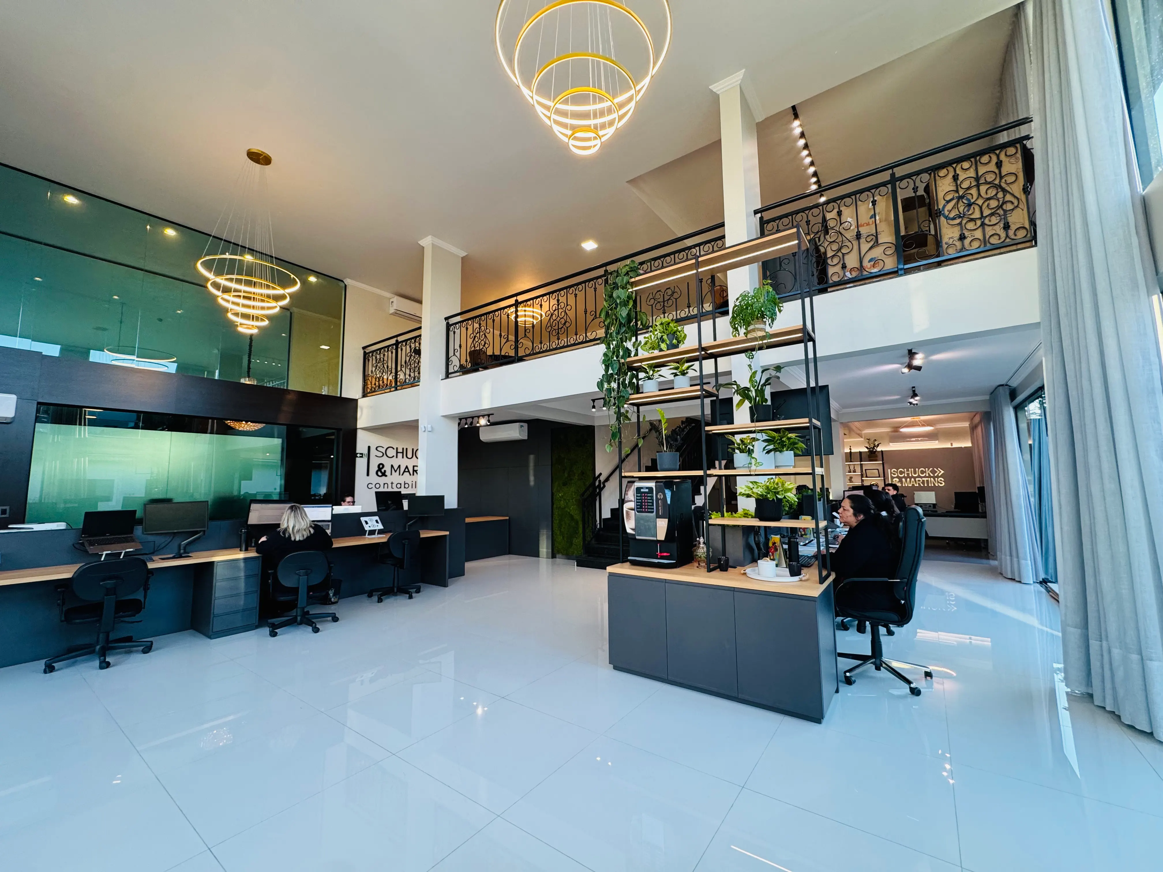 Interior da nova sede da Schuck & Martins com pé-direito duplo e mezanino